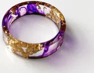 Bunter handgefertigter Harzring mit getrockneten Blumen und Goldfolie