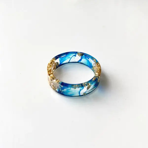 Bunter handgefertigter Harzring mit getrockneten Blumen und Goldfolie