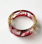 Bunter handgefertigter Harzring mit getrockneten Blumen und Goldfolie