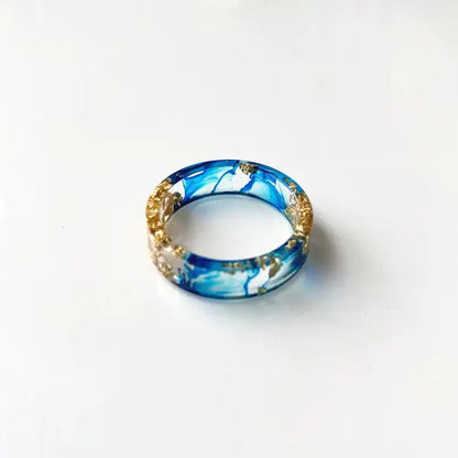 Bunter handgefertigter Harzring mit getrockneten Blumen und Goldfolie